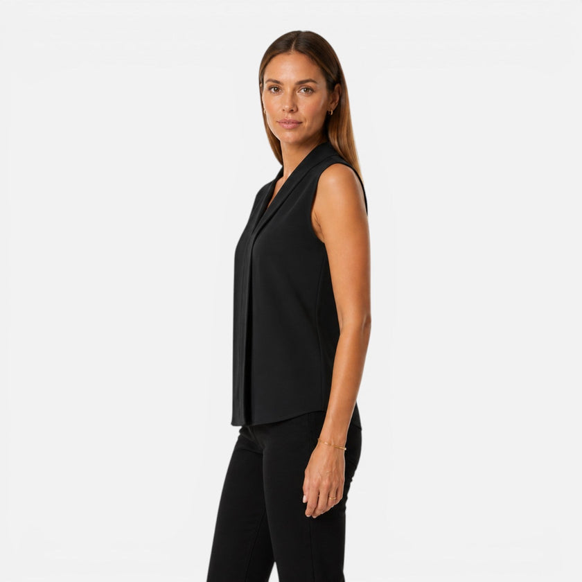 FJØRNA women's sleeveless blouse with elegant draped V-neck and timeless fit, shown on a model.
