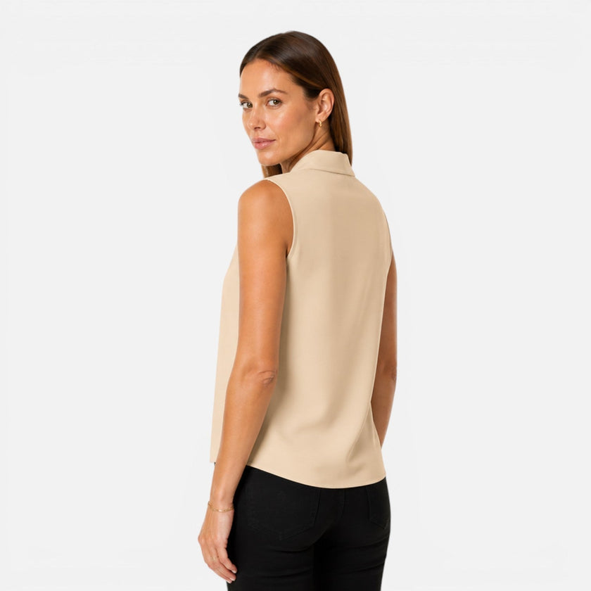 Women's sleeveless blouse by FJØRNA featuring an elegant draped V-neck and timeless fit, shown in a stylish, natural pose.