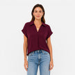 Lightweight women's V-neck short sleeve blouse by FJØRNA with a relaxed fit, shown on a model.