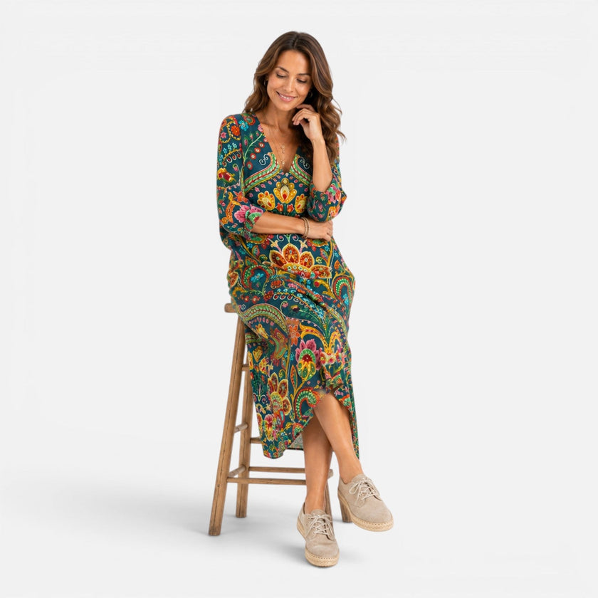 FJØRNA women's Bohemian floral maxi dress with flowing fabric and vibrant floral pattern displayed on a mannequin.