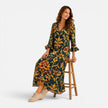 FJØRNA women's bohemian floral maxi dress with flowing fabric, vibrant floral pattern, and sleeveless design on model.