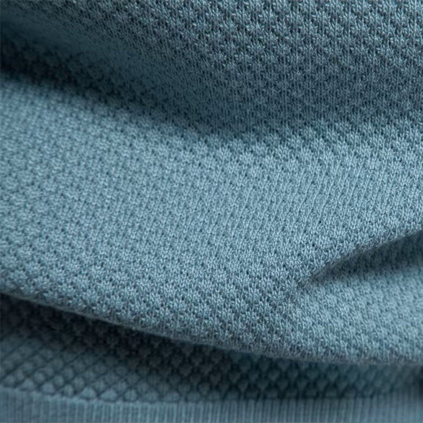 Men's slim fit knit polo shirt by FJØRNA, lightweight and breathable, shown in a natural pose highlighting the collar and fabric texture.