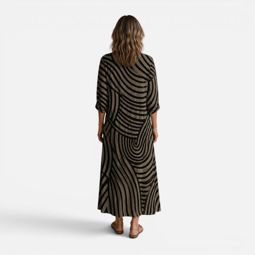 Women's flowy maxi dress by FJØRNA featuring an abstract print, lightweight fabric, and a relaxed, elegant fit.