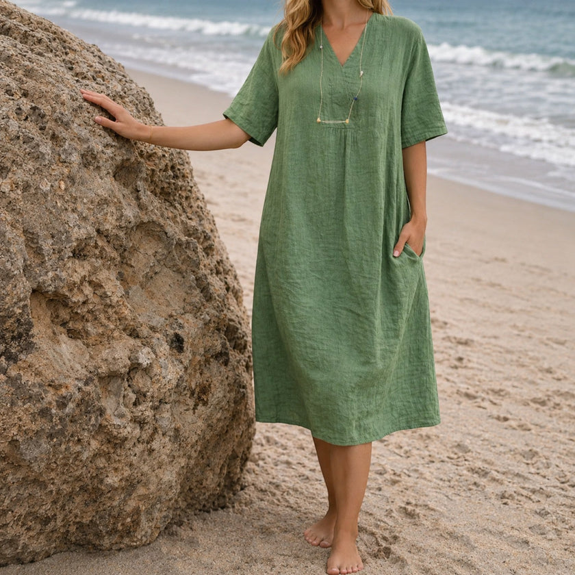 Women's linen beach dress by FJØRNA featuring a casual V-neck, loose fit, and midi length for summer beachwear.