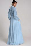 Light blue FJØRNA Fizza Plunge Ruch Maxi Dress featuring a flowing silhouette and elegant ruching detail.
