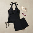 FJØRNA women's summer swimsuit with halter neck and ruched design, flat lay showing the stylish swimwear for beach or pool.