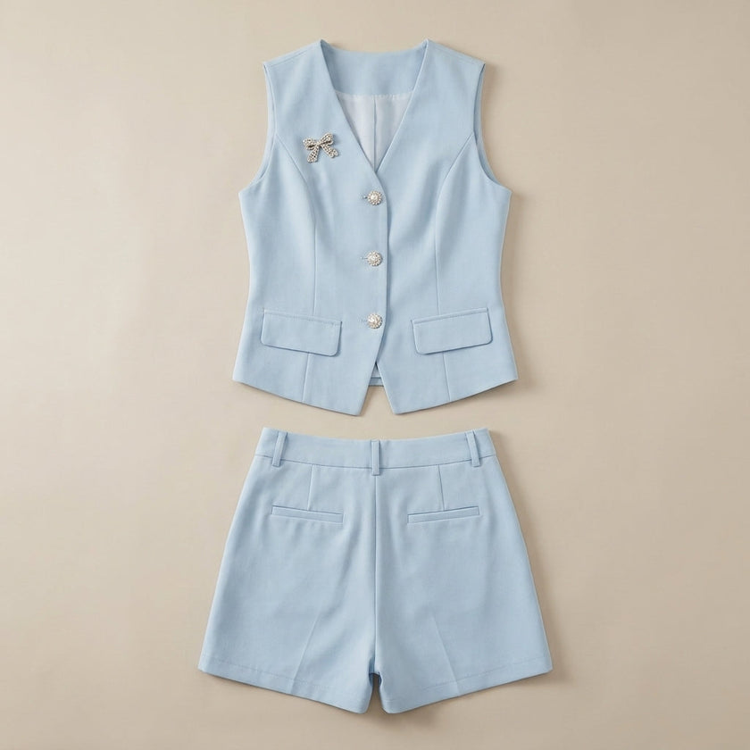 FJØRNA summer women's two-piece set with pockets, V-neck top and matching shorts, laid flat on a neutral background.