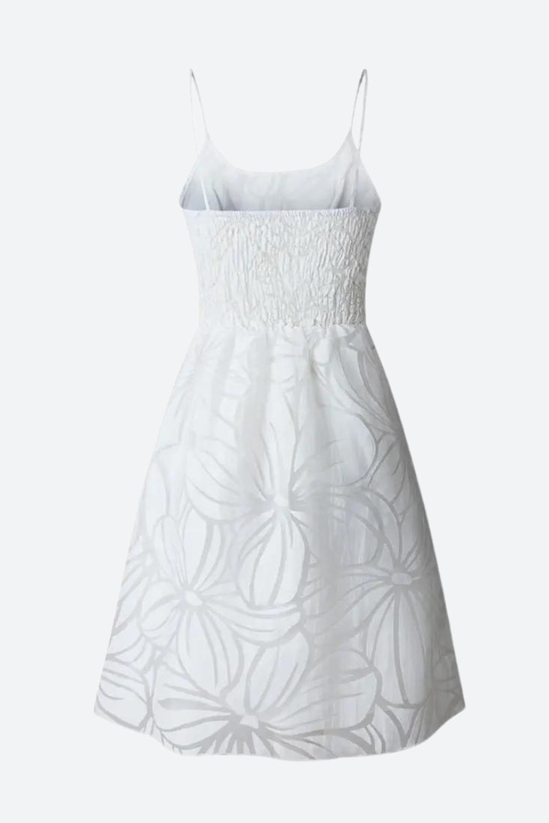 White floral ruffled mini dress by FJØRNA, featuring delicate ruffles and a feminine silhouette, shown on a model.