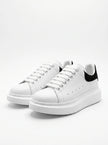 White FJØRNA men's lace-up trainers with minimalist design, ideal for everyday wear, shown from the front view.