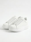 White lace-up men's trainers by FJØRNA, minimalist design, perfect for everyday casual wear, front view of the shoes.