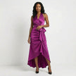 Fuchsia satin halter neck maxi dress by FJØRNA with bow tie waist and ruffled hem, styled on a mannequin.