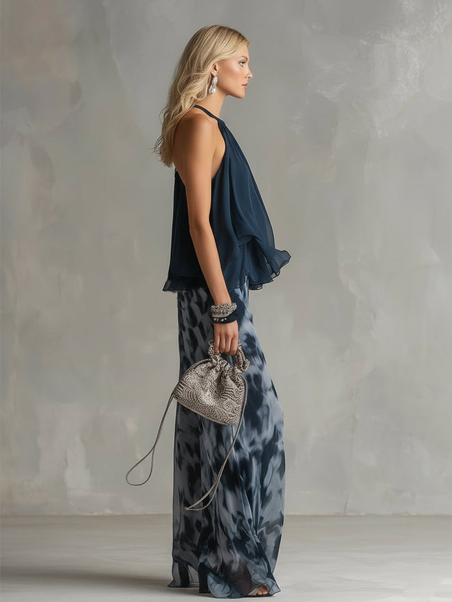 Navy blue printed wide-leg FJØRNA women's pants with a relaxed fit and flowing fabric, stylishly draped on a model.