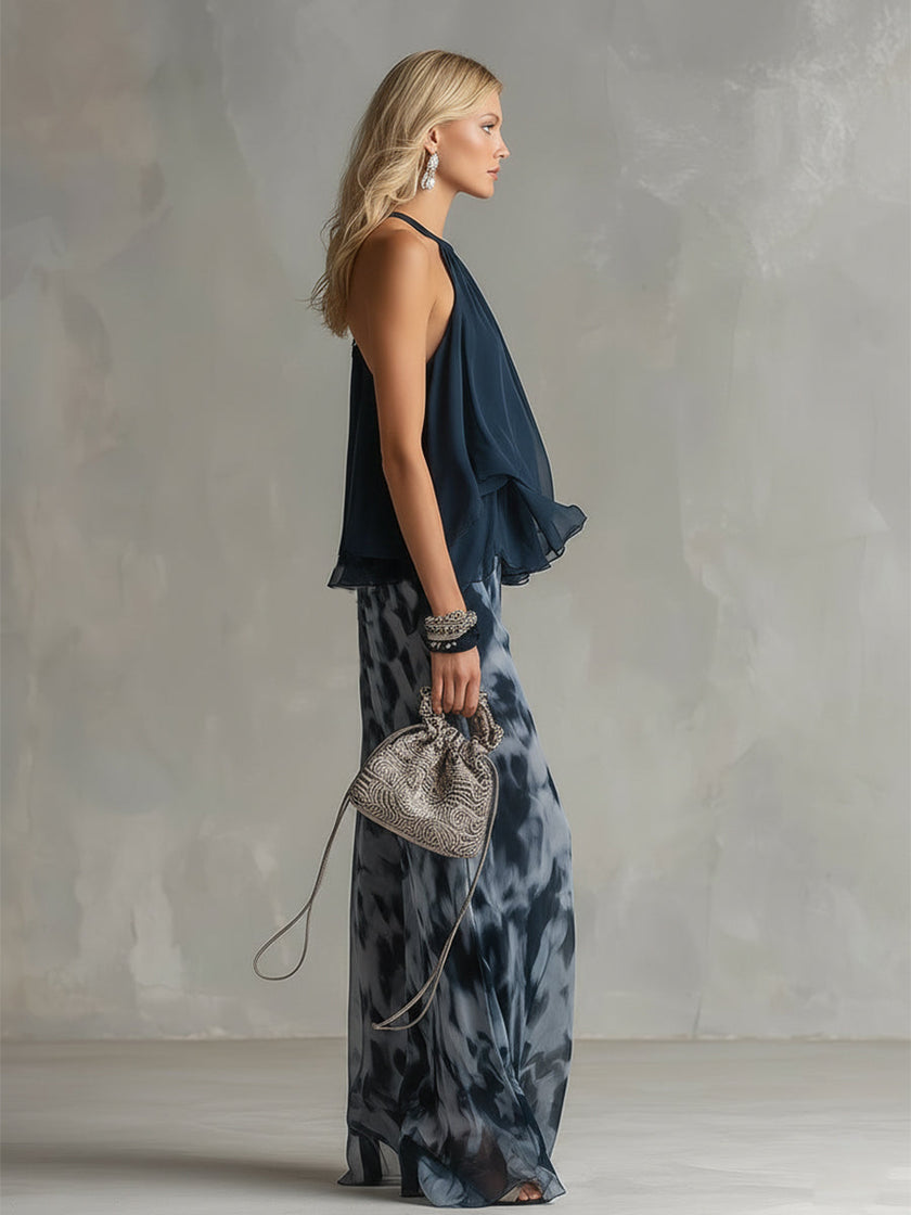 Navy blue printed wide-leg FJØRNA women's pants with a relaxed fit and flowing fabric, stylishly draped on a model.