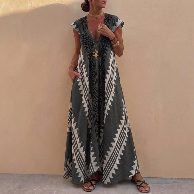 Gray FJØRNA elegant maxi dress for women with a geometric V-neck, flowing fabric, and stylish design.