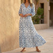 Gray FJØRNA V-neck maxi dress with ruffled hem, flowing fabric, and elegant design perfect for summer or casual wear.