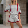 Gray FJØRNA sporty two-piece set with contrast trim, featuring a relaxed off-shoulder top and matching pants.