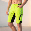 Men's green outdoor performance shorts by FJØRNA with zippered pockets, designed for comfort and active wear.