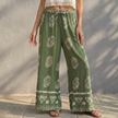 Green women's cotton wide-leg trousers by FJØRNA, relaxed fit with a flowy silhouette for summer wear.