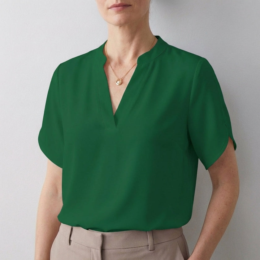 Green FJØRNA women's summer blouse with V-neck, short sleeves, and flowy fabric, perfect for warm weather.