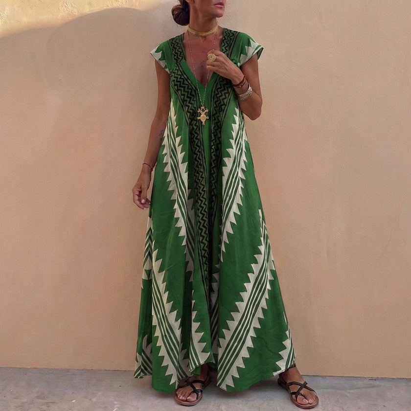 Green bohemian-inspired flowing maxi dress with deep V-neck and geometric motifs by FJØRNA, showcasing its relaxed, elegant style.