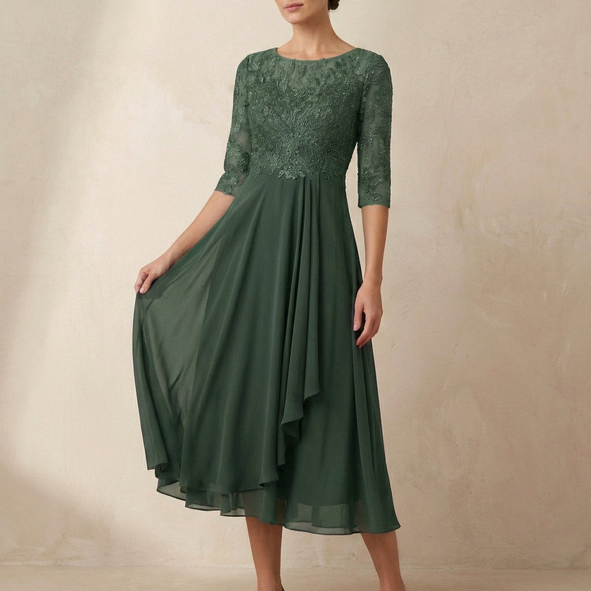 Green embroidered FJØRNA A-line midi dress with sheer sleeves and pockets, stylish and elegant for casual or formal wear.