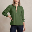 Green FJØRNA summer blouse for women with long sleeves and smocked design, shown on a model.