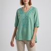 Green FJØRNA women's summer blouse with floral pattern, V-neck, linen fabric, and slit detail, perfect for warm weather.