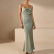 Green satin fitted cowl neck maxi dress with spaghetti straps by FJØRNA, perfect for elegant evening occasions.