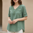 Green floral V-neck linen blouse for women by FJØRNA, casual summer top with a relaxed fit and feminine design.