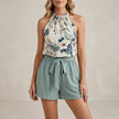 FJØRNA tropical halter blouse and tie-waist relaxed shorts set in green, featuring a floral print and lightweight fabric.