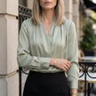 Green FJØRNA women's summer blouse with V-neck and long satin sleeves, casual style, perfect for warm weather.