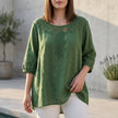 Green FJØRNA women's linen summer blouse with cut-out details, lightweight and stylish for warm weather.