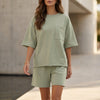 Green FJØRNA oversized two-piece set with relaxed fit, chest pocket, and wide-leg shorts, casual and comfortable outfit.
