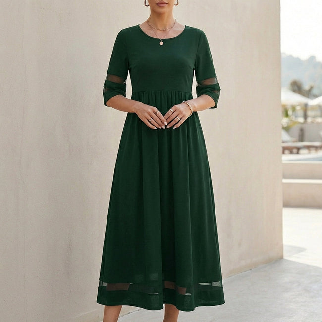 Green FJØRNA A-Line maxi dress with mesh panels and side pockets, flowing midi-length style for women.