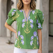 Green floral summer blouse for women with V-neck, puff sleeves, and high waist by FJØRNA, shown on a model.