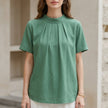 Green FJØRNA summer blouse for women with a high neck and short sleeves, stylish and lightweight top for warm weather.
