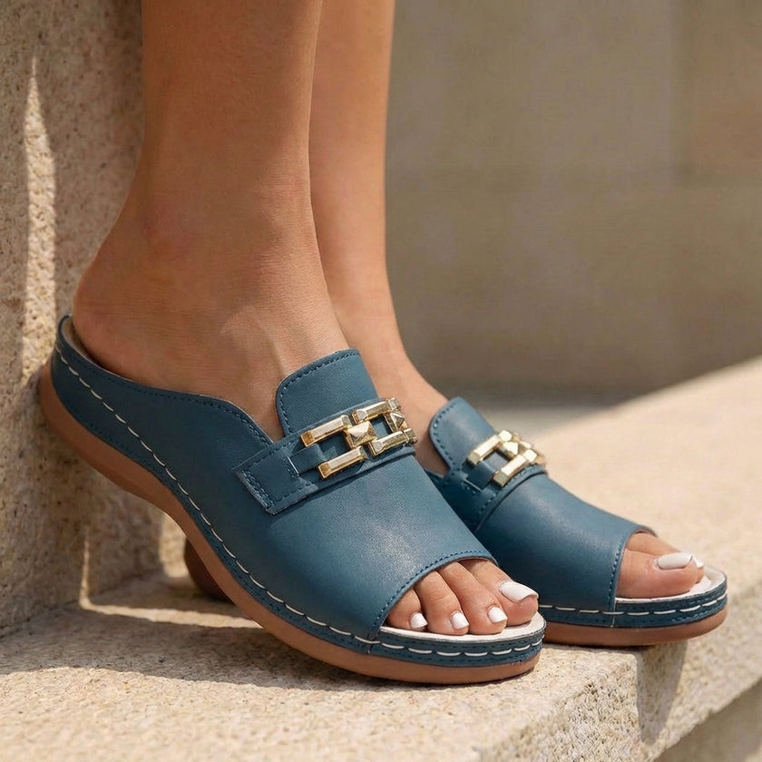 Green FJØRNA orthopedic slip-on sandals with buckle embellishment, showcasing comfortable design and stylish foot support.