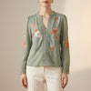 FJØRNA women's summer floral blouse with V-neck and long sleeves, in vibrant green fabric, perfect for warm weather style.