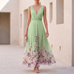 Green floral A-line maxi dress by FJØRNA featuring sleeveless design and V-neck, styled with a flowy, elegant silhouette.