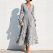 FJØRNA floral print long-sleeved V-neck pleated dress with elegant design, featuring a floral pattern and flowing fabric.