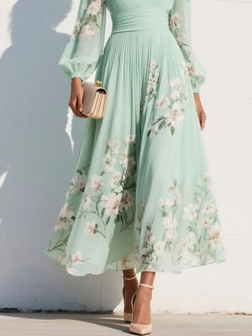 FJØRNA floral print long-sleeved V-neck pleated dress displayed on a hanger with a soft fabric texture and elegant floral pattern.