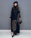 White floral motif knit long dress by FJØRNA with a flowing silhouette and intricate floral patterns.