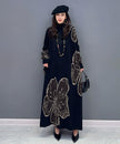 FJØRNA floral motif knit long white dress with intricate floral patterns and a flowing silhouette.