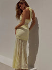 FJØRNA lace maxi dress featuring intricate lace fabric and flowing silhouette, perfect for elegant occasions.