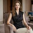 FJØRNA women's sleeveless satin summer blouse with V-neck, styled casually with a relaxed fit and soft fabric.