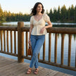 FJØRNA women's summer blouse with sweetheart neckline and puff sleeves, styled in a casual outdoor setting.