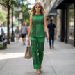 FJØRNA loose sleeveless top with asymmetrical hem paired with wide-leg pants in a stylish 2-piece set shown in a casual lifestyle setting.
