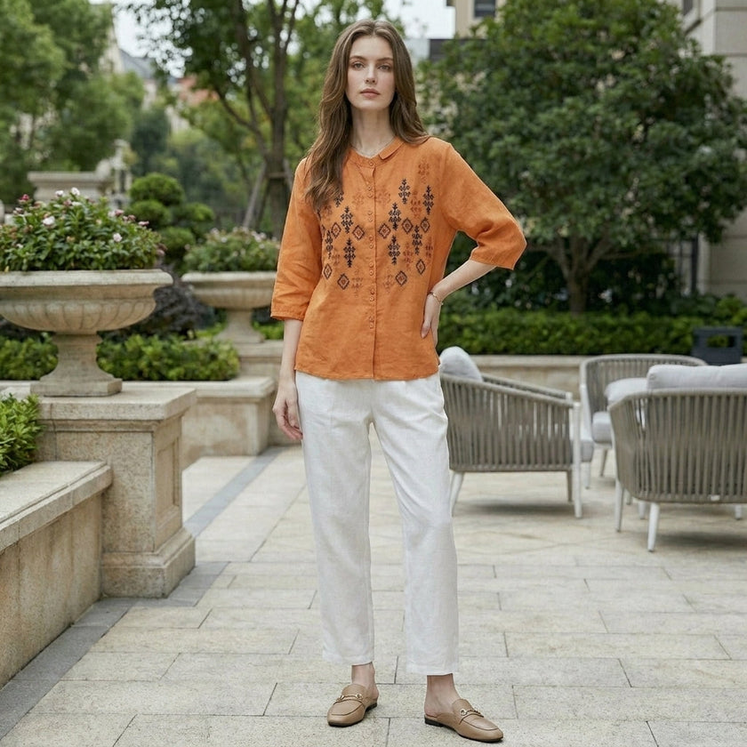 FJØRNA women's summer blouse with geometric pattern and button front, styled as a casual top in a lifestyle setting.