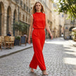 Elegant FJØRNA two-piece women's co-ord set with high waist pants and high neck top, styled in a casual outdoor setting.