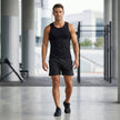 Men's FJØRNA athletic shorts with elastic waistband and side slits, shown in a relaxed lifestyle setting.